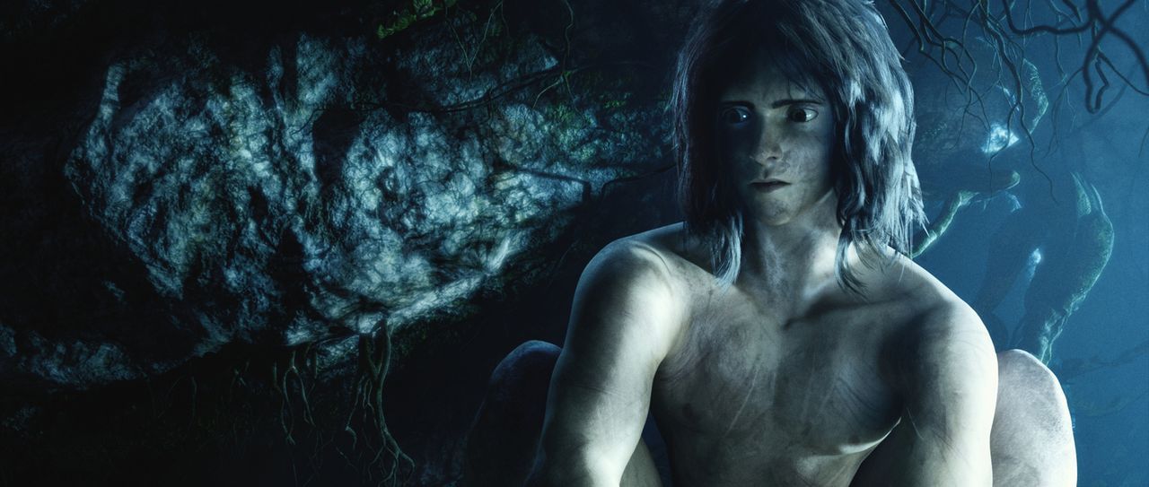 Vom Dschungel gezeichnet sitzt Tarzan nachdenklich in einer dunklen Höhle des Dschungels. - Bildquelle: Constantin Film