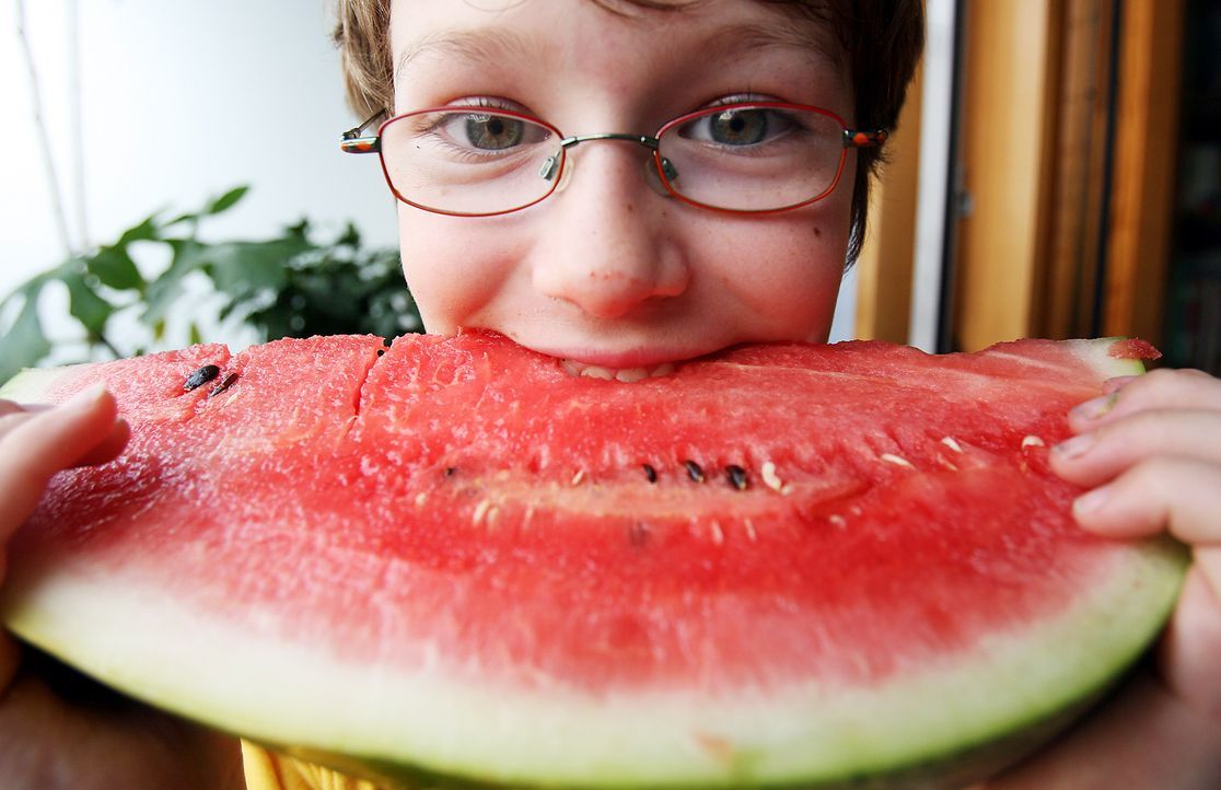 Kind beißt in eine Wassermelone - Bildquelle: dpa