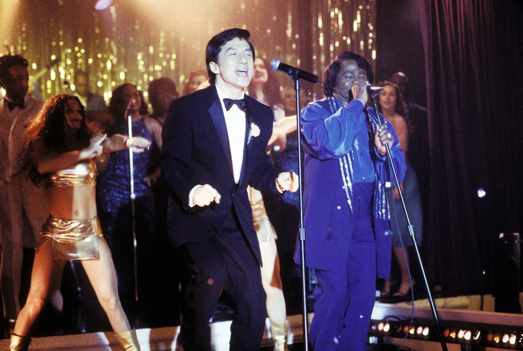 Kaum hat Jimmy (Jackie Chan, l.) den Anzug seines im Koma liegenden Chefs an, da befindet er sich auch schon auf der Bühne, wo er die Vertretung von... - Bildquelle: TM &   2002 DreamWorks LLC. All Rights Reserved