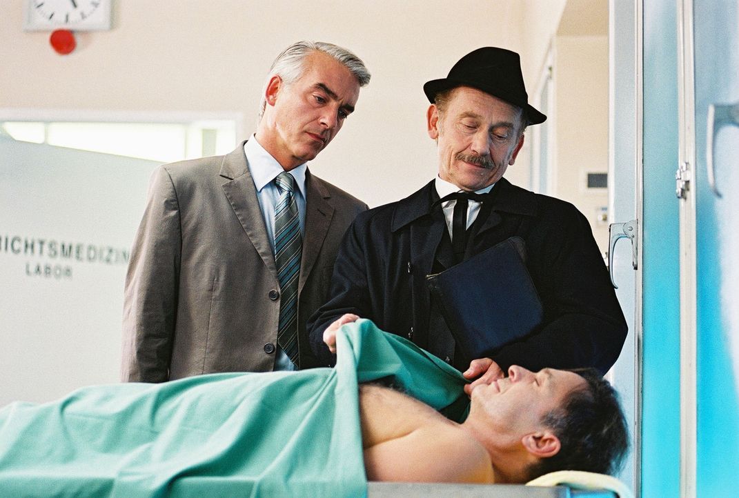 Felix (Christoph M. Ohrt, l.) und Bestatter Paulsen (Tilo Prückner, r.) betrachten den toten Horst Windeck (Jockel Tschiersch, liegend). - Bildquelle: Hardy Spitz Sat.1