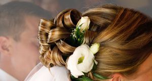Romantisch und natürlich: Blumen im Haar lockern die Brautfrisur auf.