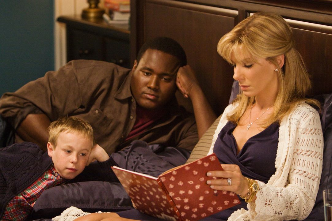 Als der obdachloser Teenager Michael Oher (Quinton Aaron, l.) zufällig auf Leigh Anne Tuohy (sandra Bullock, r.) und ihre Familie (Jae Head, M.) tr... - Bildquelle: Warner Brothers