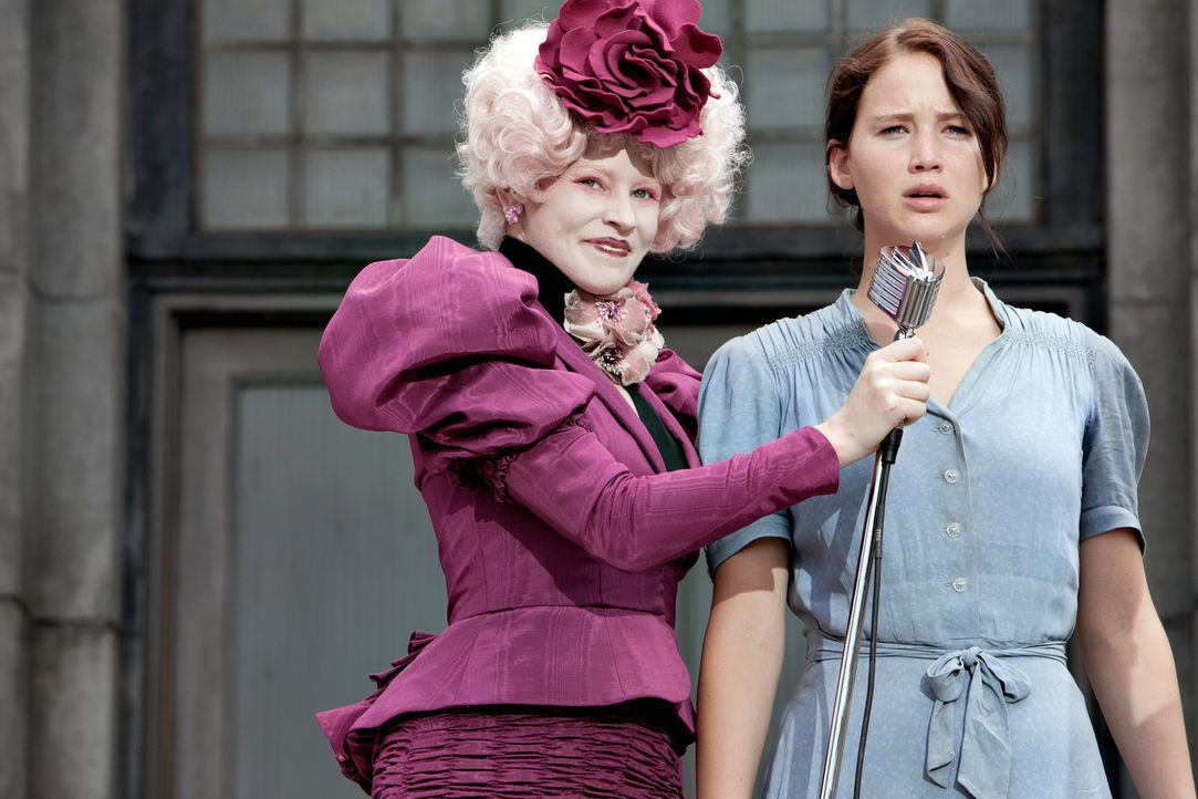 Kaum in der Arena angekommen, wird Katniss (Jennifer Lawrence, r.) von ihrer Betreuerin Effie Trinket (Elizabth Banks, l.) auf die Bühne gezogen. Vo... - Bildquelle: Studiocanal GmbH
