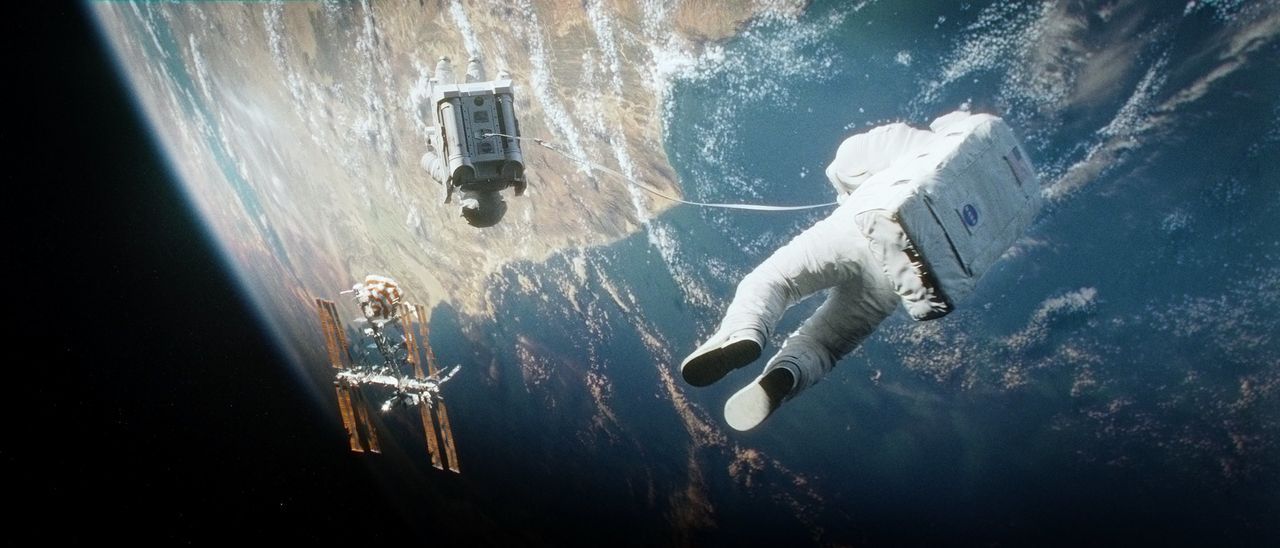 Als Trümmerteile ihr Shuttle zerstören, sind der altgediente Astronaut Matt Kowalski (George Clooney, r.) und die Biomedizinerin Dr. Ryan Stone (San... - Bildquelle: Warner Brothers