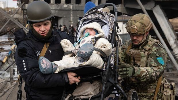 Soldaten tragen ein Kind in seinem Kinderwagen während der Evakuierung aus Ir...
