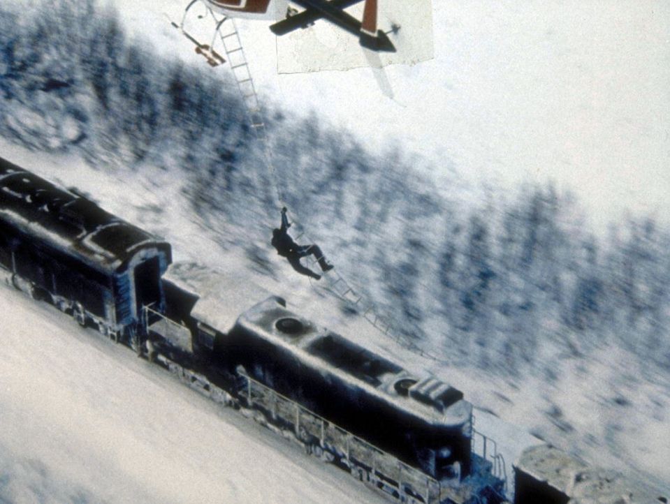 Der sadistische Gefängnisdirektor Ranken (John P. Ryan) seilt sich von einem Hubschrauber auf den fahrenden Zug ab, um Rache zu üben. - Bildquelle: Cannon Releasing Corp.